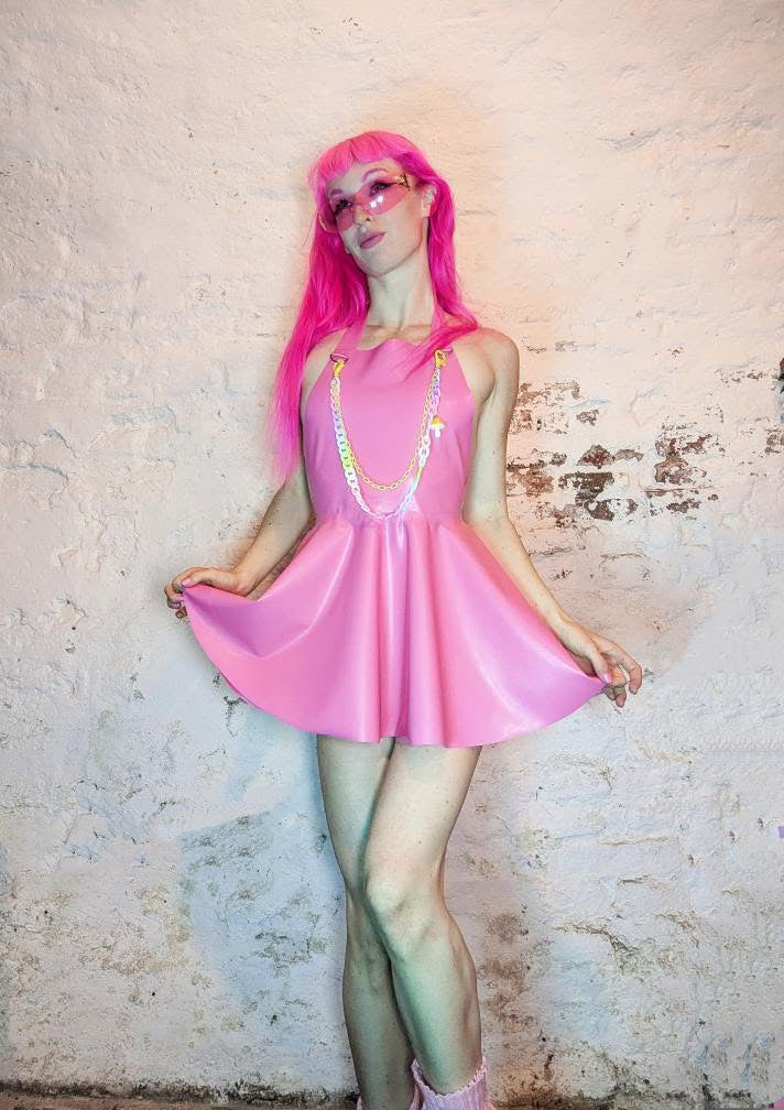 meisje met roze latex halterjurk en regenboog ketting