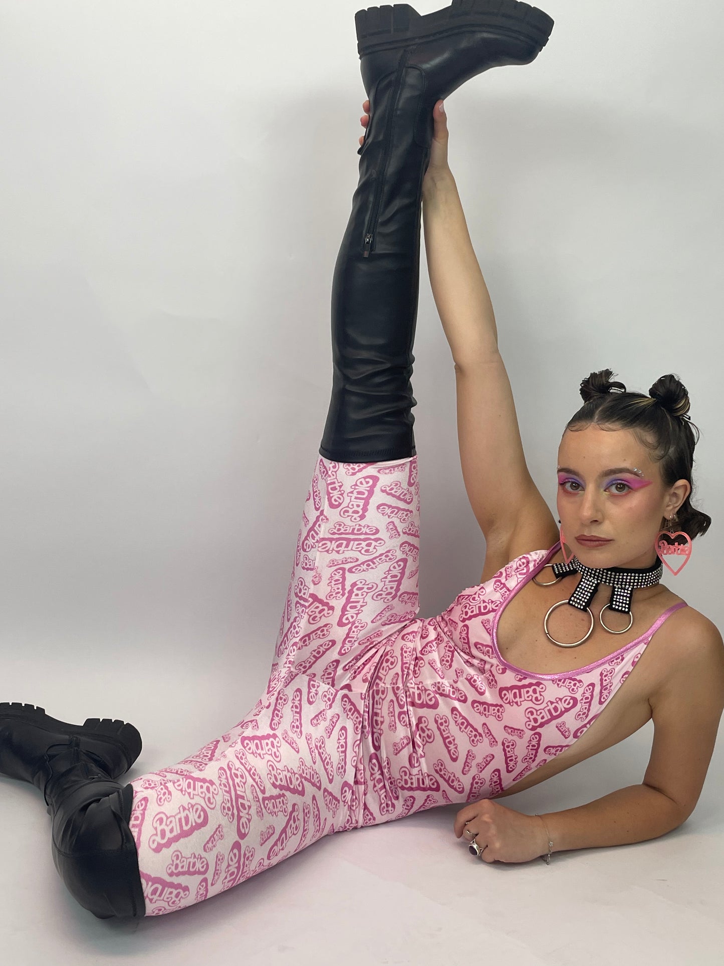 meisje die haar been omhoog houdt en een barbie catsuit aan heeft, ravewear