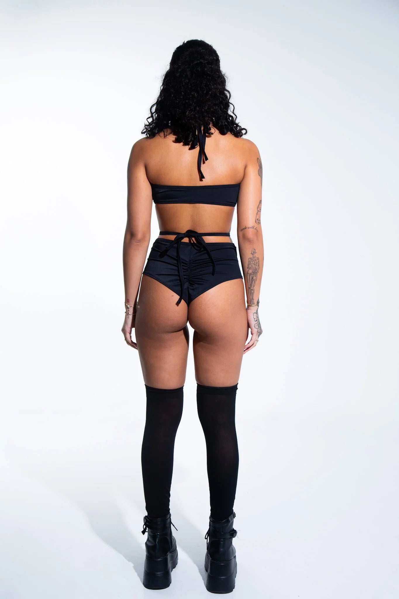 achterkant van vrouw met zwarte rave outfit aan