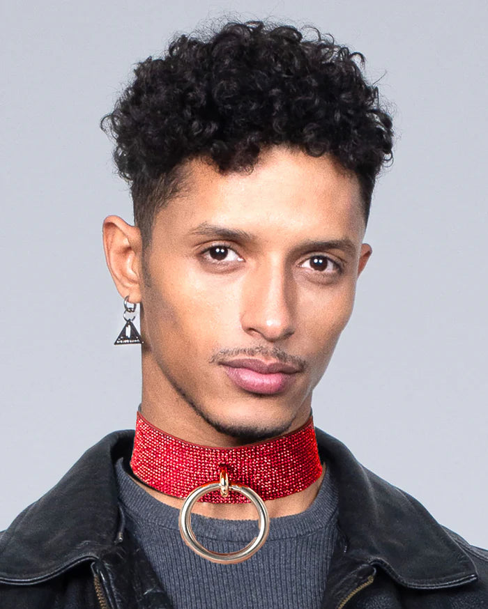 jongen met rode rhinestone choker en ring
