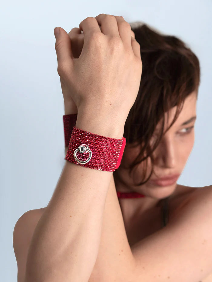 vrouw met rode kristallen bezette armband