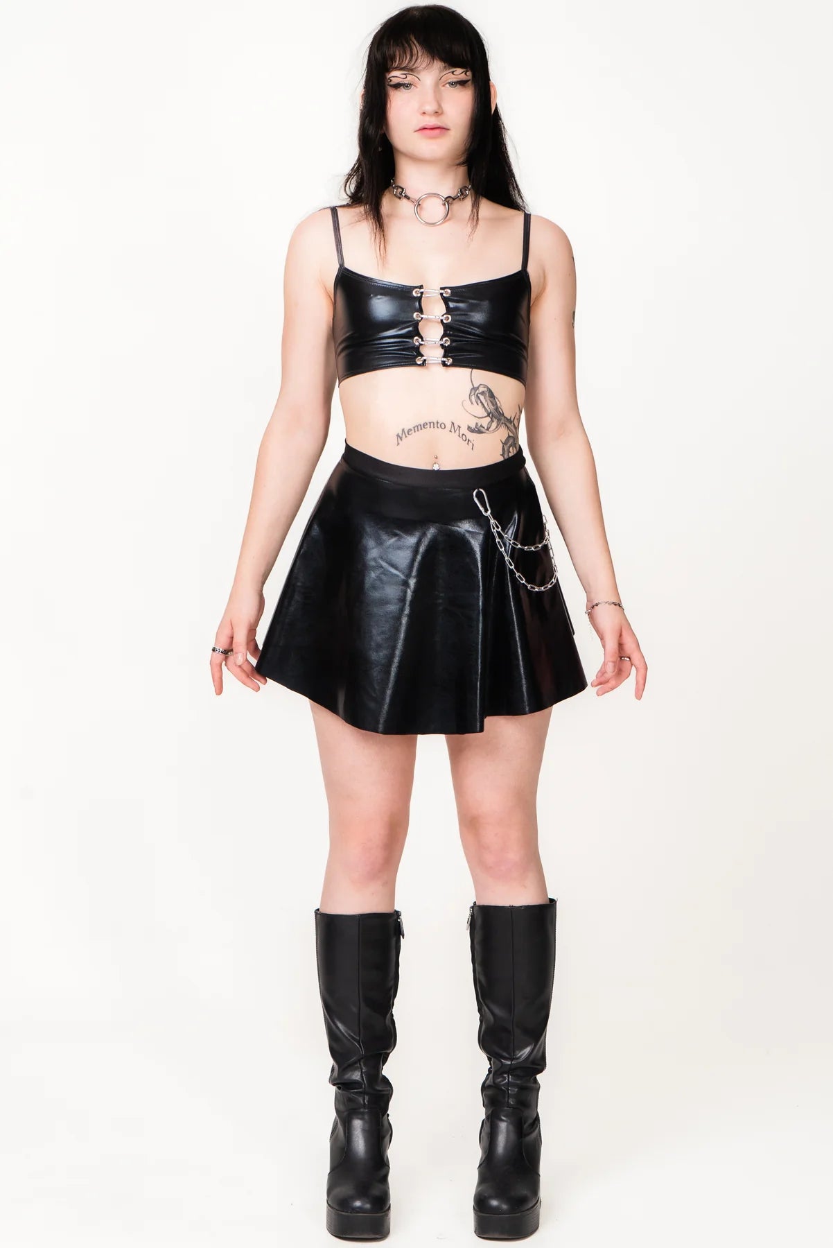 meisje met zwarte vinyl rok aan met ketting aan de zijkant