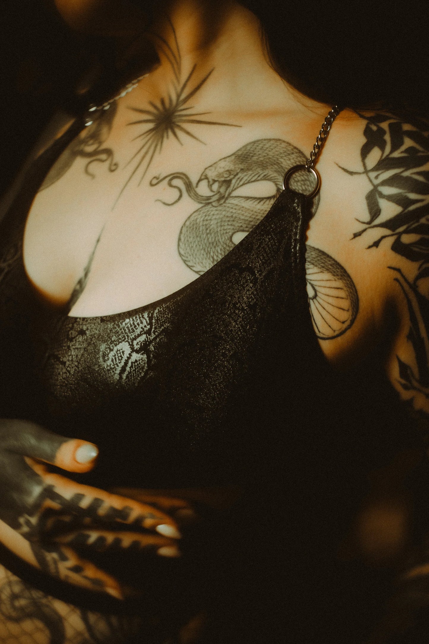 close up van slangenprint top met chains in het zwart