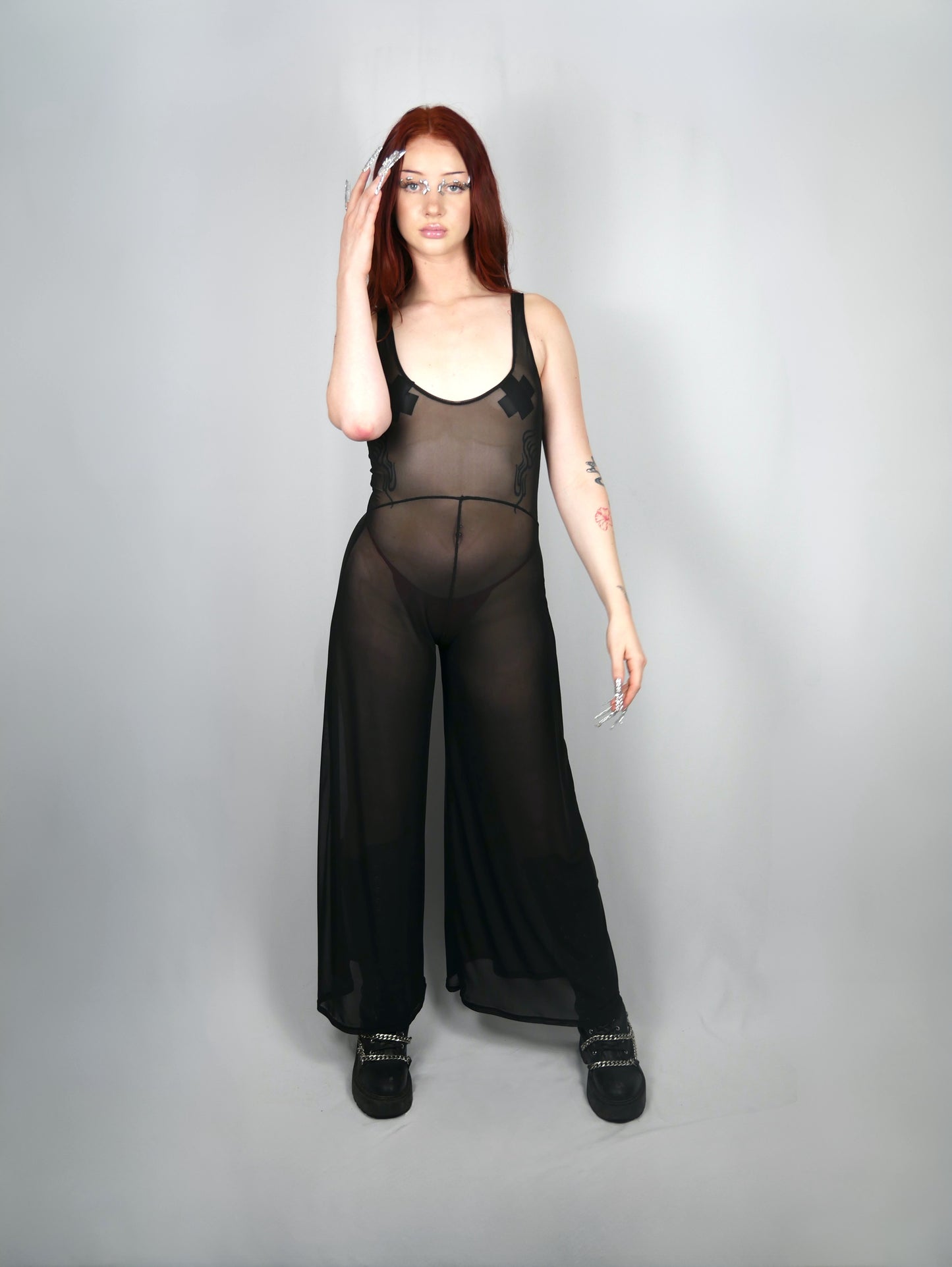 meisje met zwarte transparante mesh jumpsuit aan
