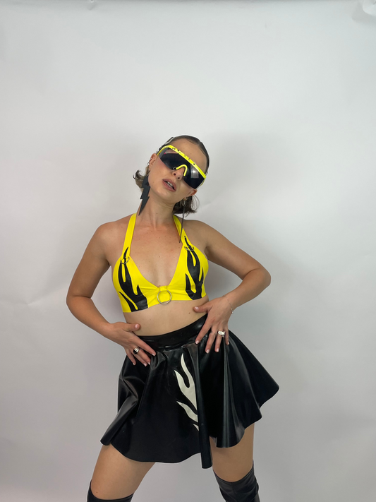 meisje met gele vlammen latex top en zwarte vlammen latex rok, techno outfit