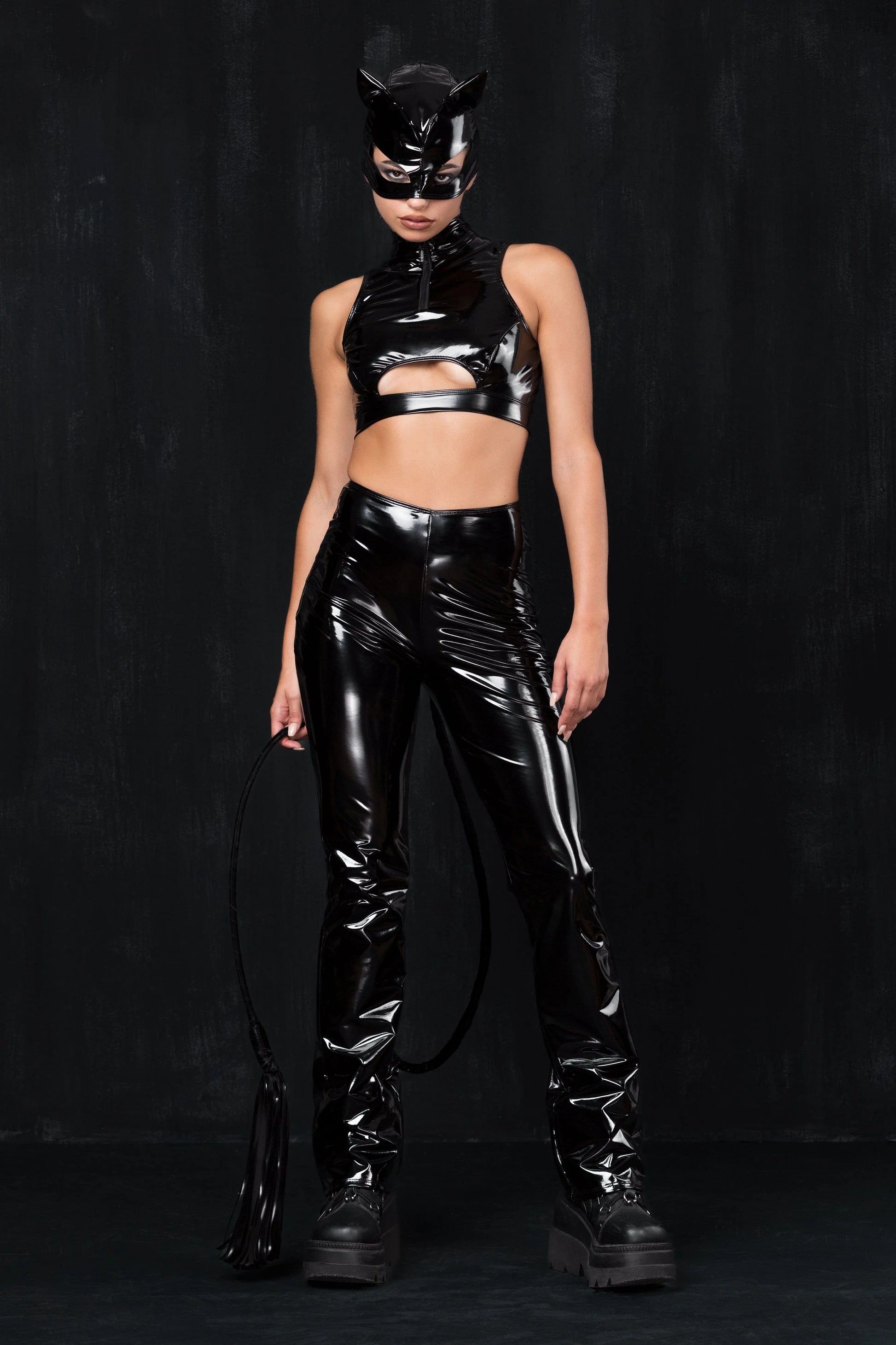 vrouw met zwarte vinyl cut out top en kattenmasker, clubwear