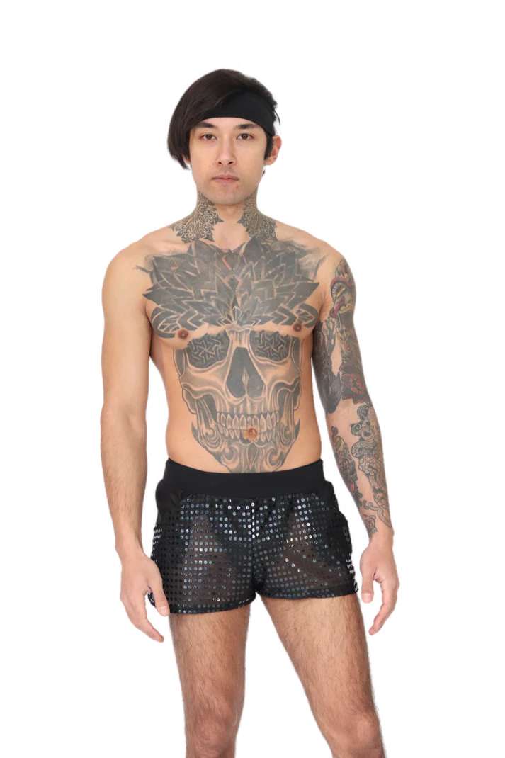 man met tattoos die een kort disco broekje aan heeft, techno outfit