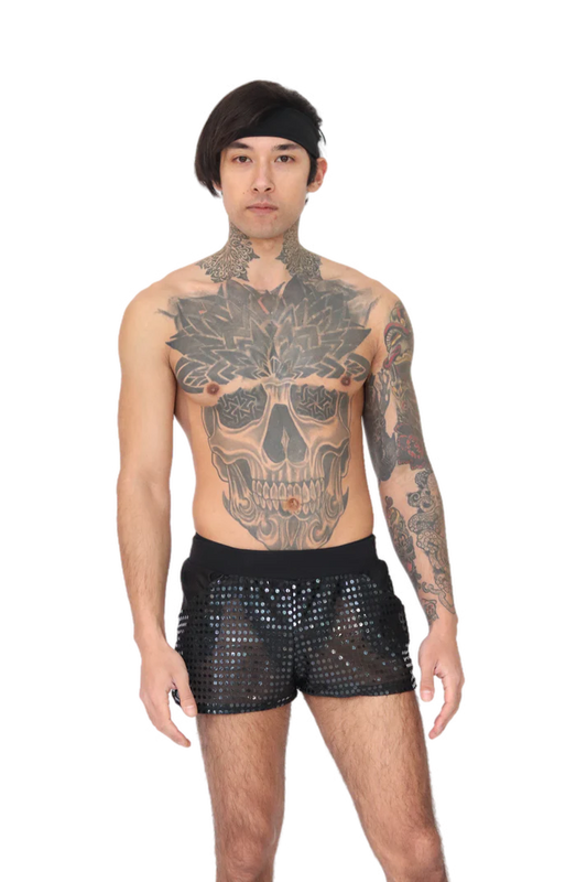 man met tattoos die een kort disco broekje aan heeft, techno outfit