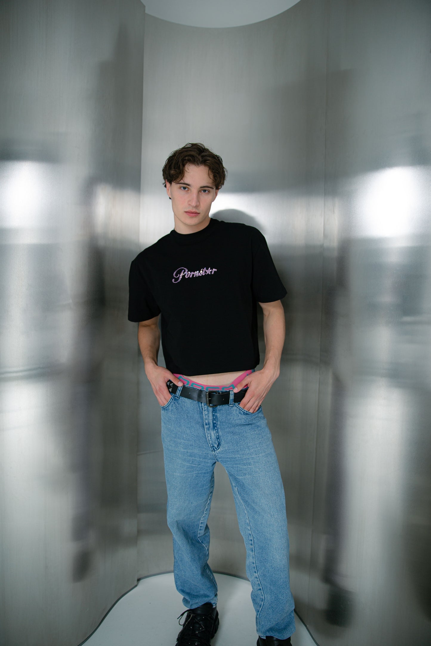 jongen met zwarte croptop met de tekst pornstar in roze gemstones, ravewear