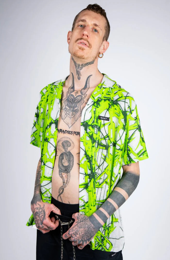 man met tattoos en witte blouse met neon groene illustratie, techno outfit