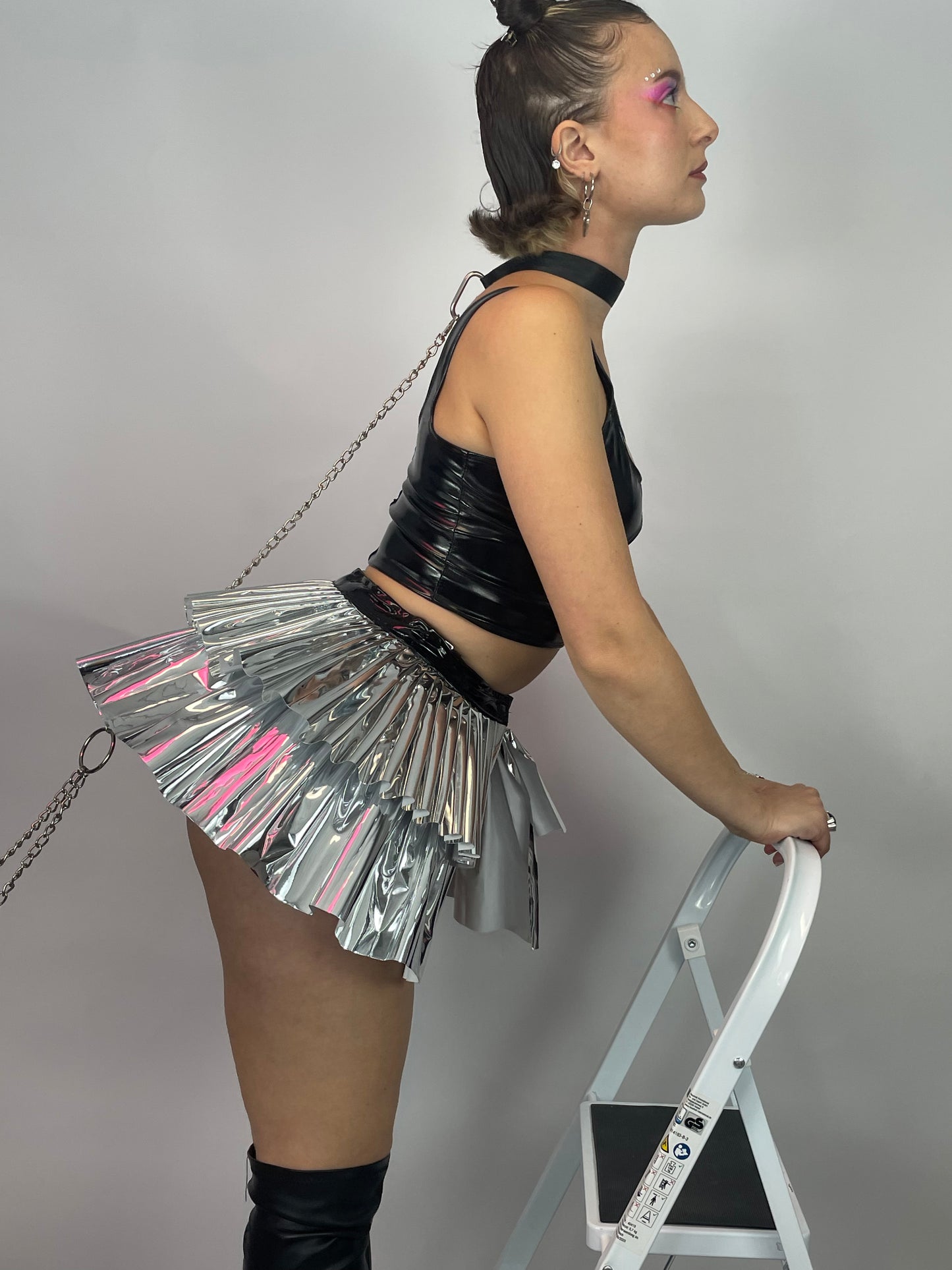 zijkant van meisje met metallic plastic tutu, techno outfit