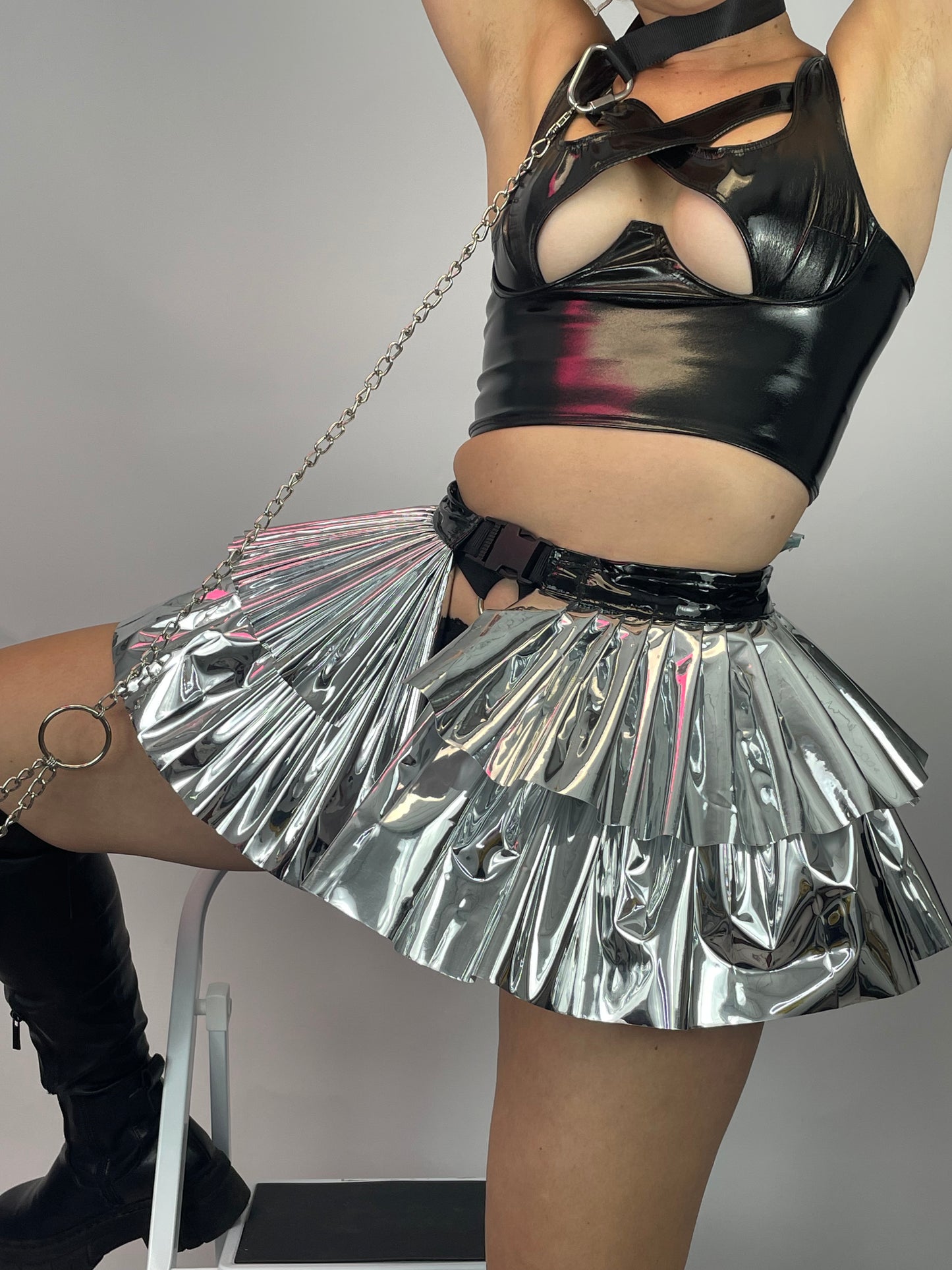 meisje met zilveren pvc plooirok, techno outfit