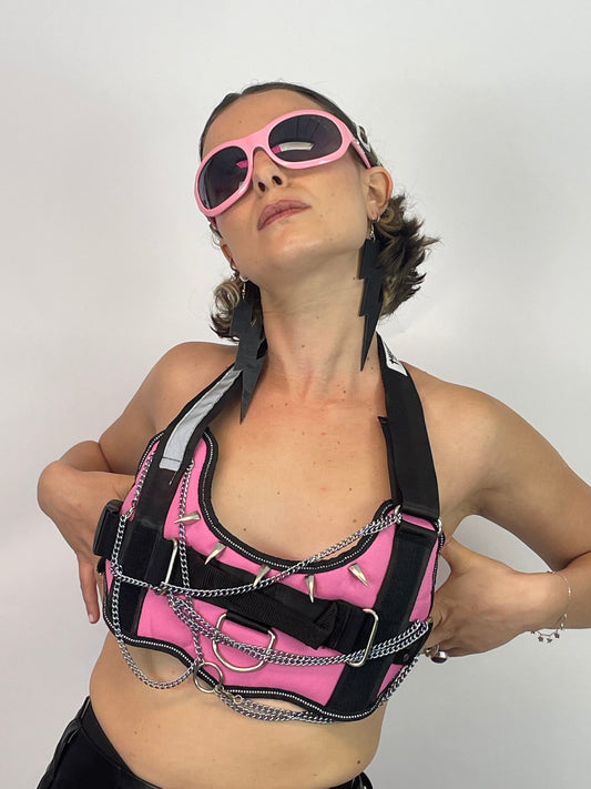 meisje met roze harnas met spikes en kettingen, techno outfit 