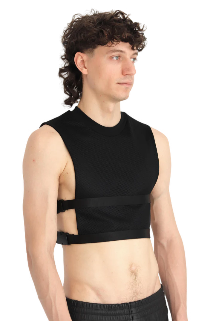 man met een zwarte crop top met buckles, ravewear