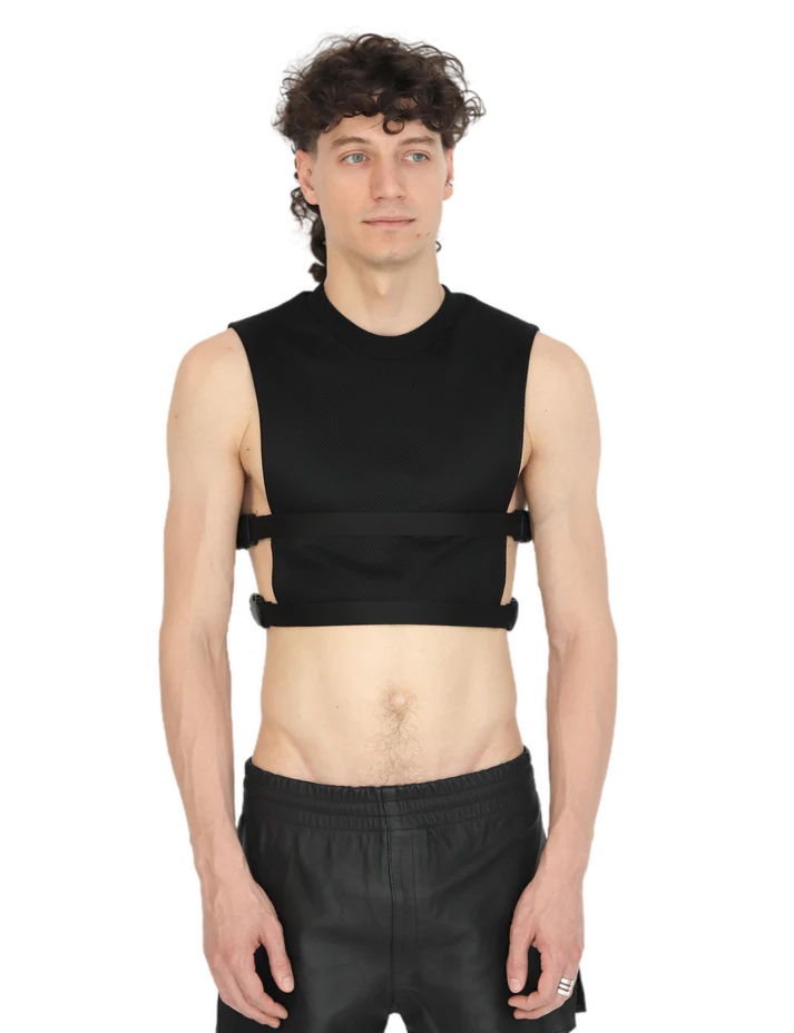 voorkant van man met zwarte crop top met gespen, ravewear