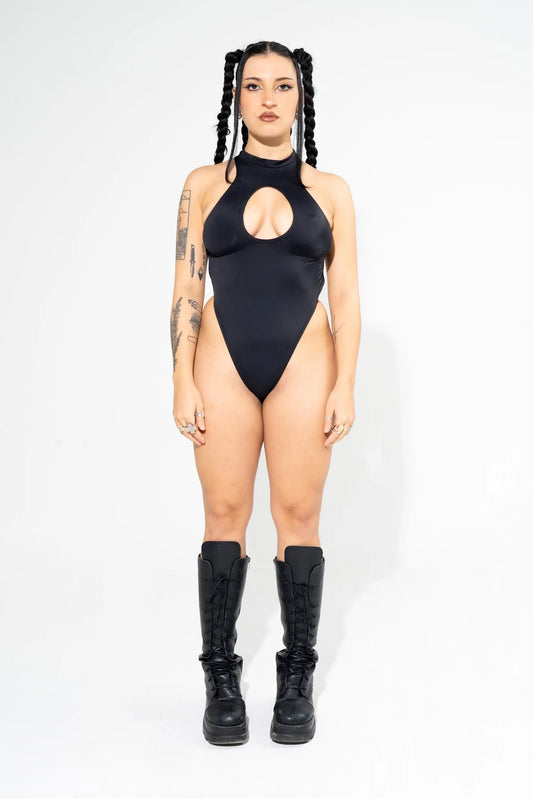 vrouw met zwarte cut out bodysuit aan 